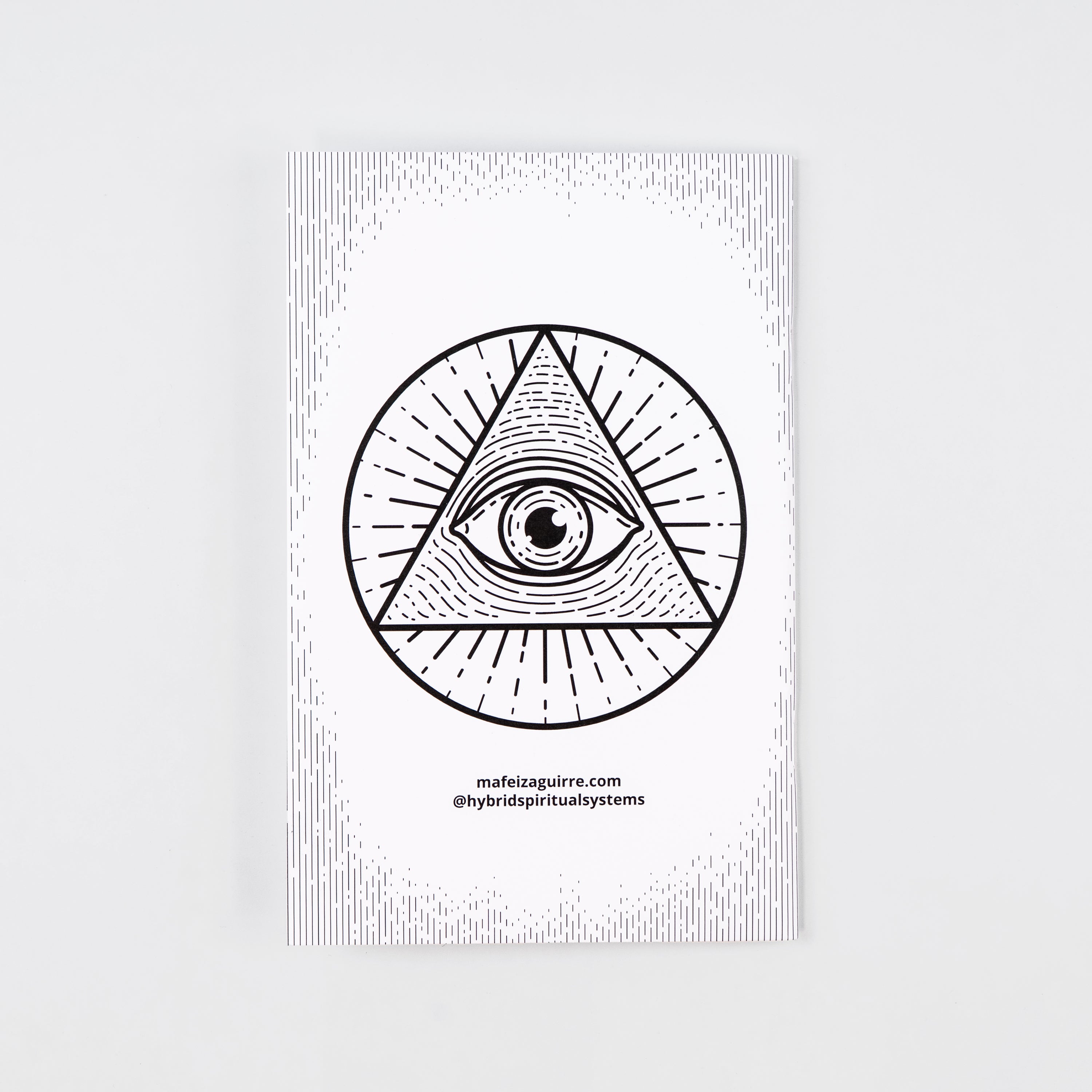 Back cover of a coloring book with an eye inside a triangle inscribed in a circle, and the text “mafeizaguirre.com @hybridspiritualsystems.”