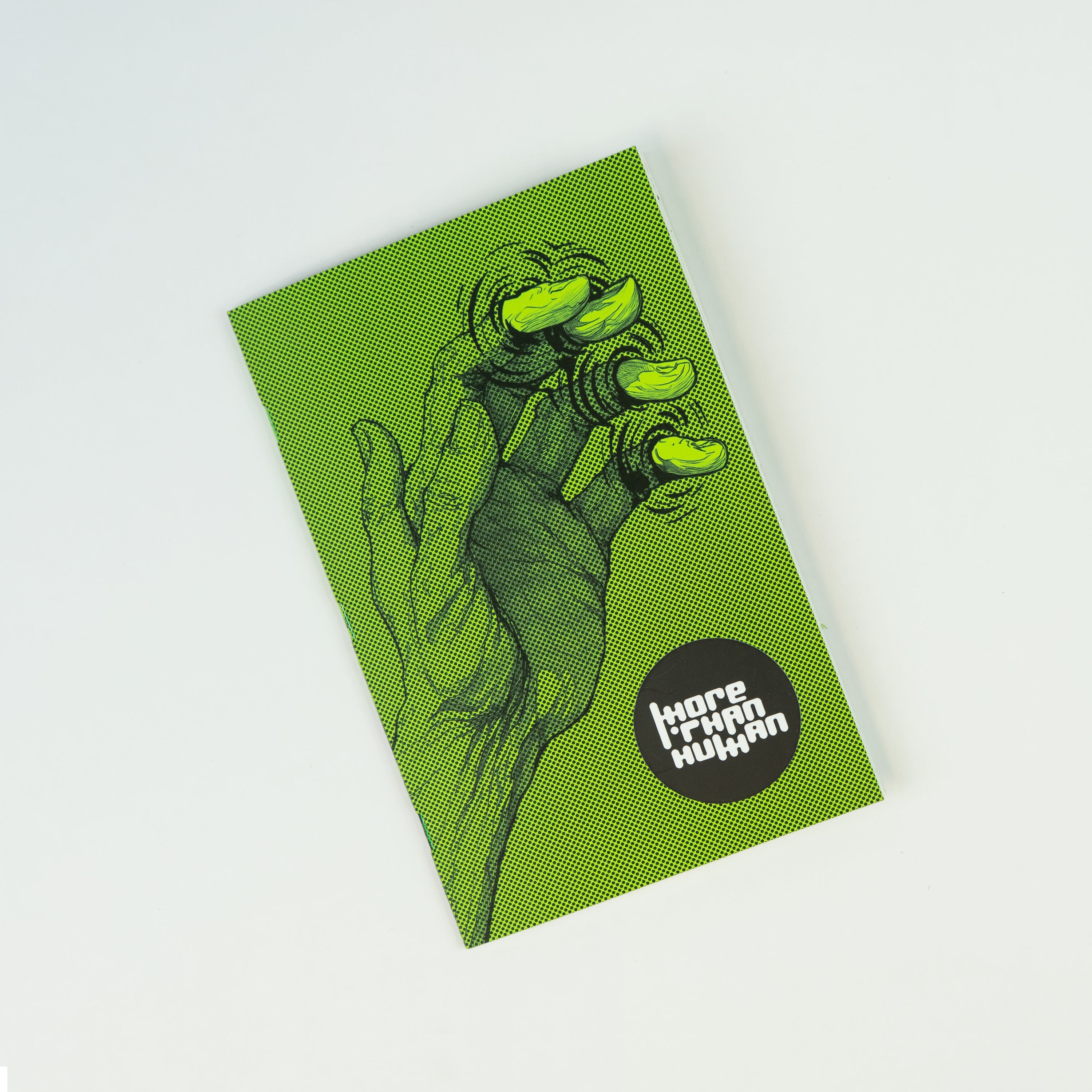 Cover of a green zine showing an illustrated six-fingered hand and a black sticker with the title “More Than Human” in white letters.