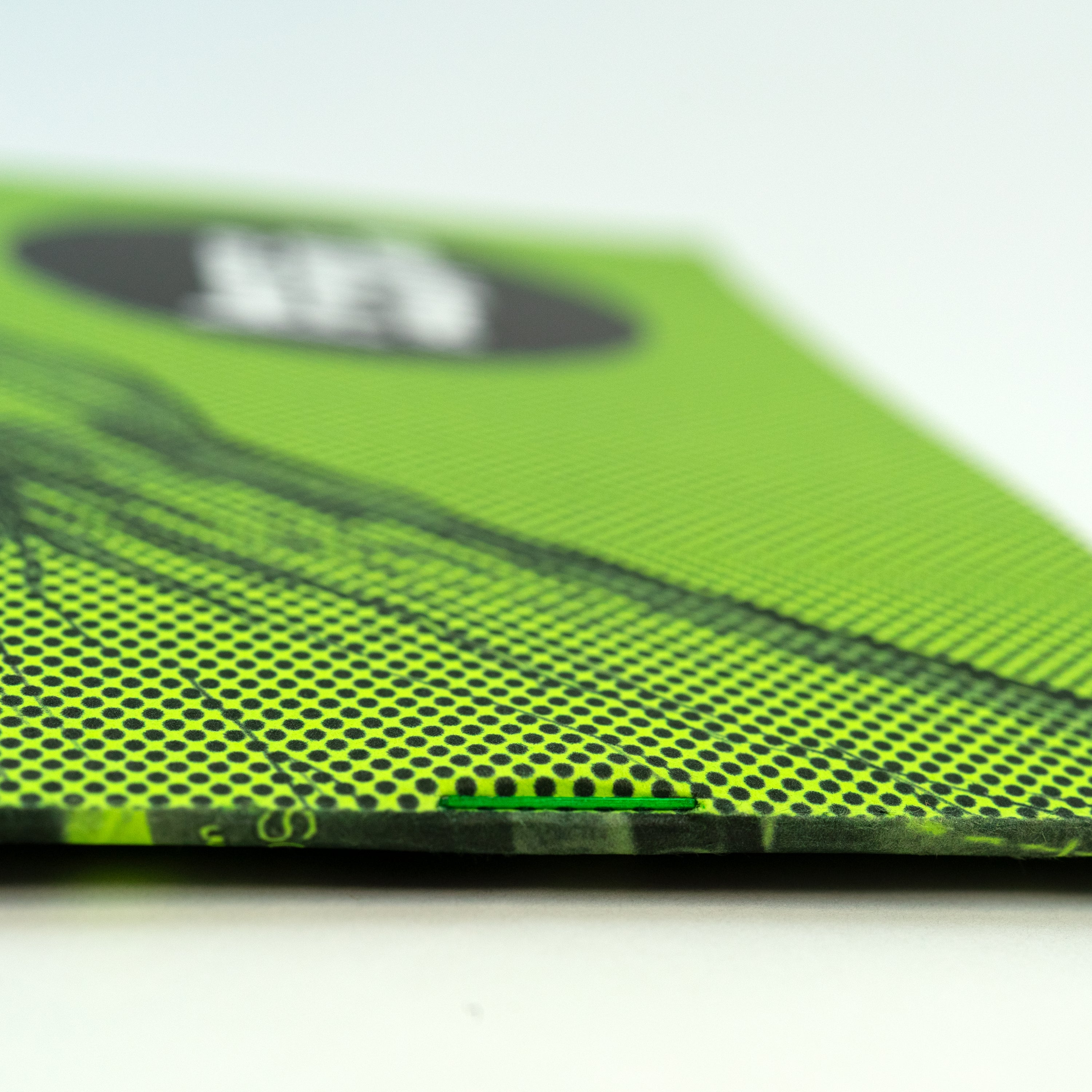 Close-up of a green staple on the spine of a green zine