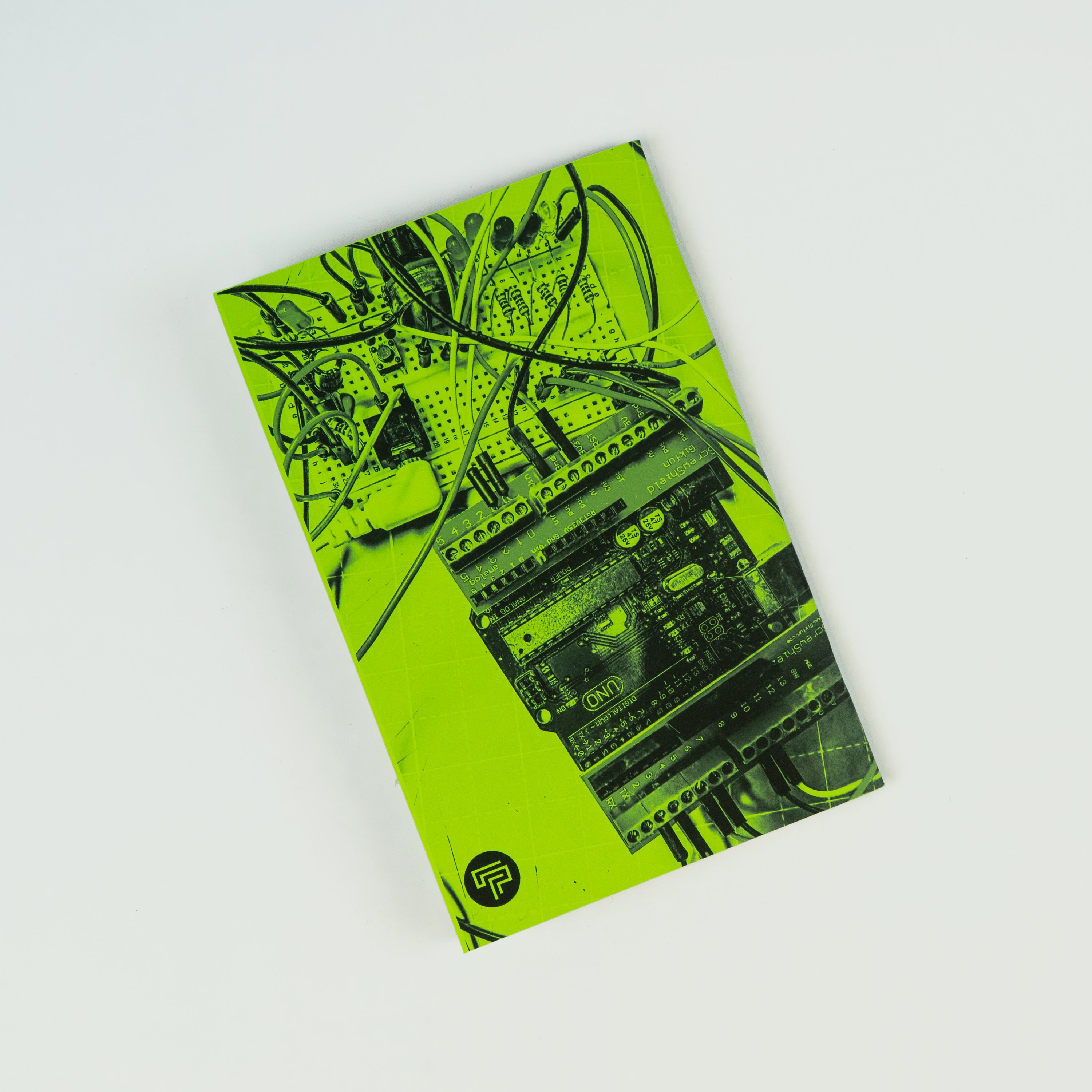 Green back cover of a zine with a photograph of an Arduino and a circuit.