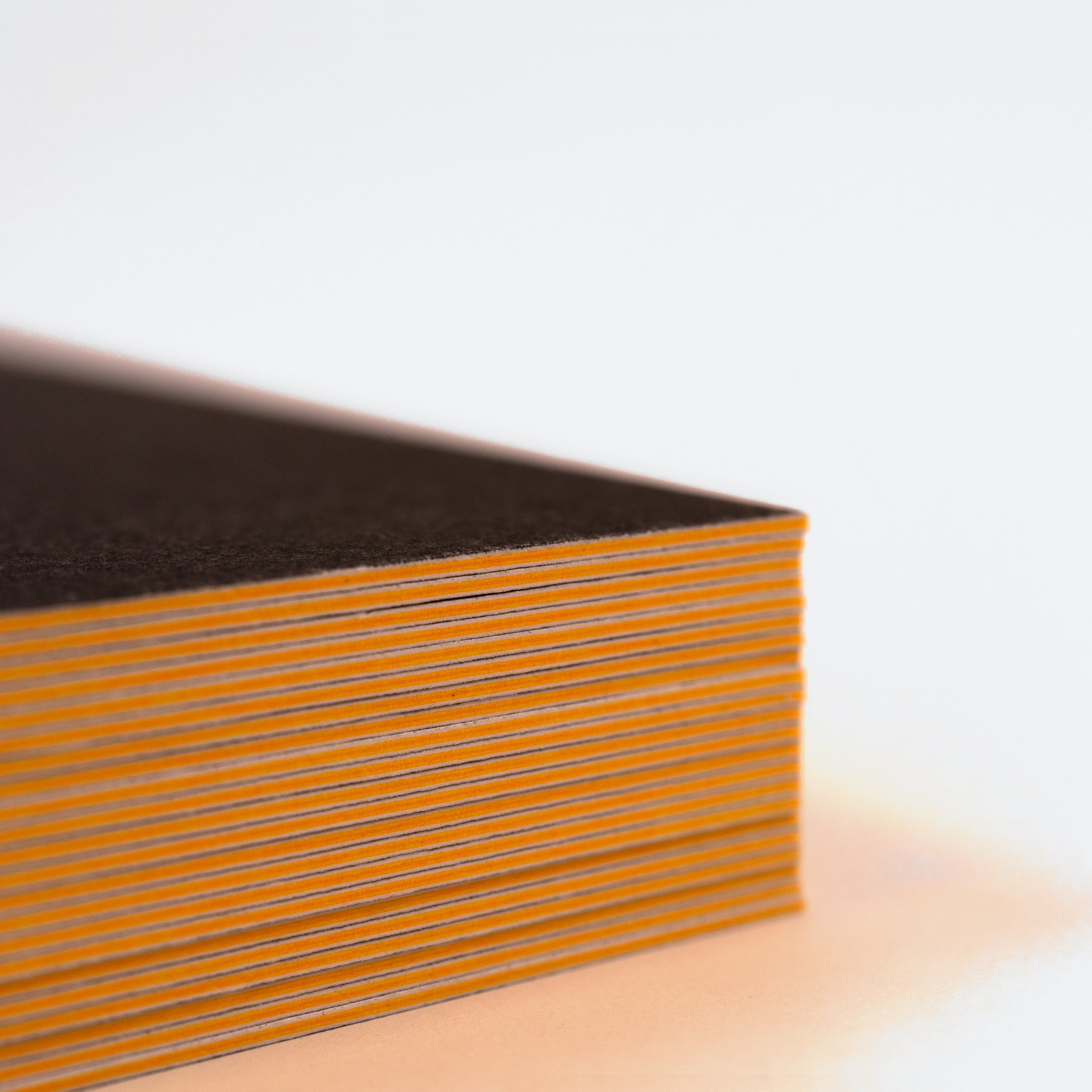 Close-up of a yellow seam on a black postcard deck.
